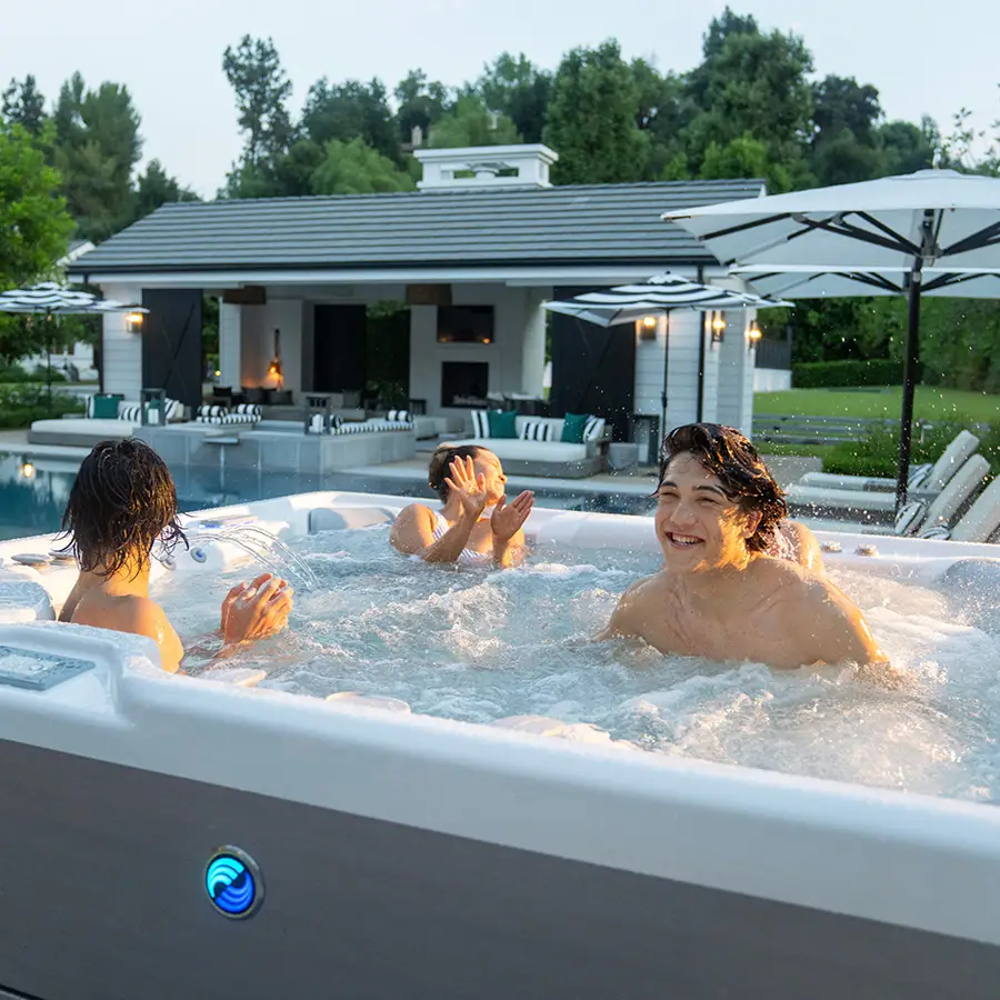 Image of kids using Grandee Hot Tub in a backyard by a pool