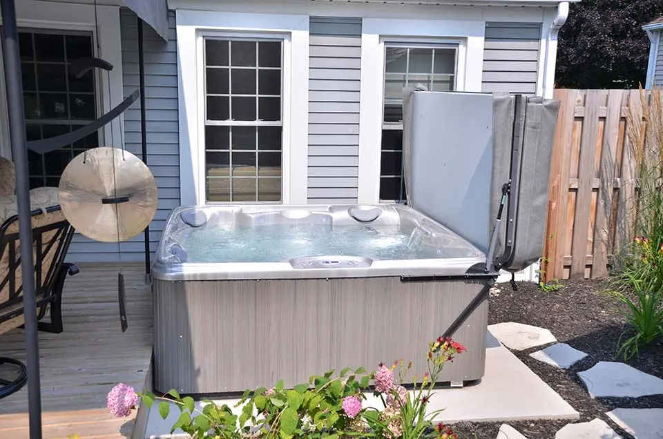 A hot tub installed on a concrete pad in a backyard